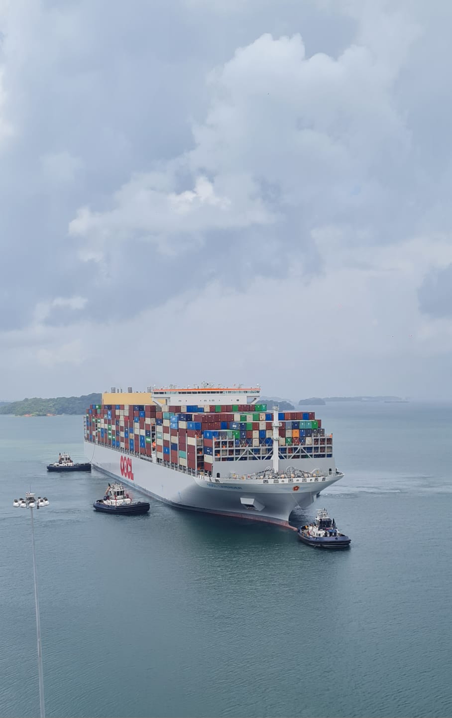 Buque portacontenedores cruzando el Canal de Panamá con remolcadores